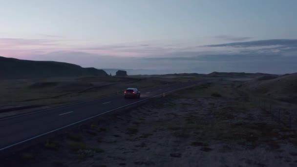 Samochód SUV jedzie na wieś po zachodzie słońca. Wycieczka po nordyckiej wsi o zmierzchu. Śledzenie pojazdu. Islandia — Wideo stockowe