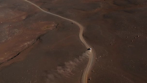 Hög vinkel syn på bilen kör på smuts vrål och stigande damm. Transport i karga vulkaniska landskap. Island — Stockvideo