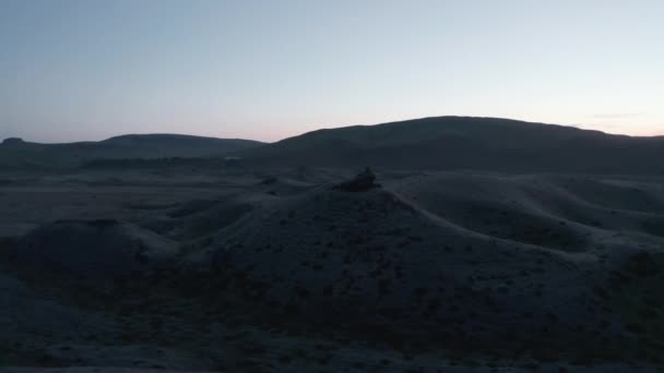 Nerovný neúrodný terén po západu slunce. Panoramatické záběry severské krajiny za soumraku. Silueta hor proti jasné obloze. Island — Stock video