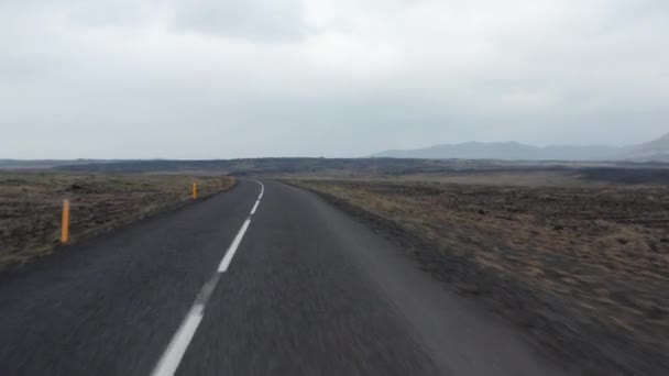 Nízký let nad silnicí procházející severskou pustinou. Neobydlená neobydlená pláň na venkově. Island — Stock video