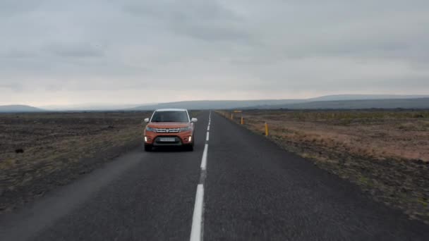 向后跟踪在农村道路上缓慢行驶的越野车。北欧多云的一天.冰岛 — 图库视频影像