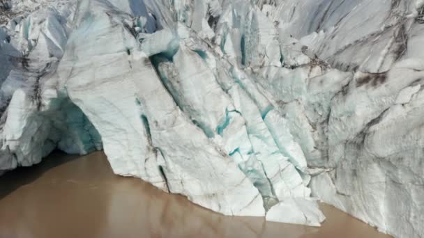 Gros plan de morceaux de glace déchiquetés sur la face avant du glacier. Images aériennes ascendantes de la fonte de la glace debout dans l'eau. Islande — Video