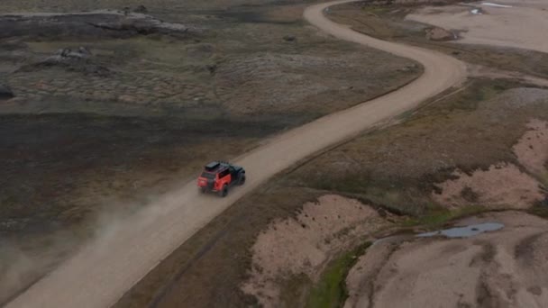 Çorak Topraklar 'da toprak yolda giden off-road aracını takip ediyor. Hareket halindeki aracın yüksek açılı görüntüsü. İzlanda — Stok video