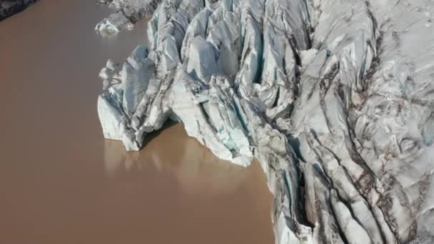 Blick auf die Wasseroberfläche und das Ende des Gletschers. Aufgekippte Gletschermassen im Tal und Berge im Hintergrund. Island — Stockvideo