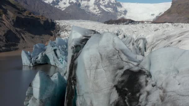 Buzulun ön tarafına yakın çekim. Kuzey dağlarındaki geniş vadiye buz kütlesi iniyor. Volkanik kül şeritli beyaz buz. İzlanda — Stok video