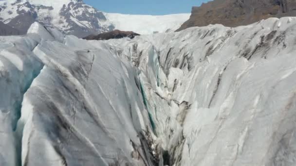 Alacsony repülés a gleccser felszíne felett. Széles völgy tele jégtömbökkel, mély hasadékokkal és rovátkákkal. Hegyi táj. Izland — Stock videók