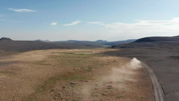 Tracciamento all'indietro del veicolo a guida veloce su strada sterrata e lasciare tracce di polvere nell'aria. Terreno vulcanico nel paesaggio nordico. Paesi Bassi — Video Stock