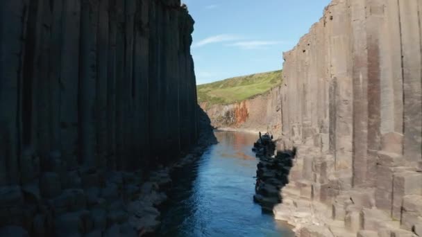 水在狭窄的山谷中流动，周围是岩石堤和玄武岩柱。风景风景。Studlagil Canyon，冰岛 — 图库视频影像