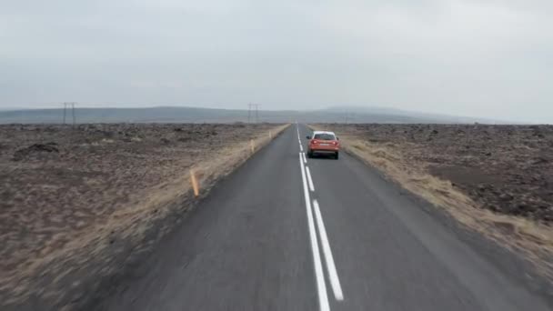 Suivi avant de la voiture SUV conduisant sur la route et passant avec une autre voiture. Lignes électriques à haute tension traversant les plaines. Islande — Video