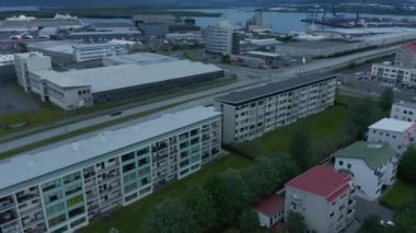 Çok katlı apartmanlar ve sanayi veya lojistik siteler arasında düşük trafiğin yüksek açılı görüntüsü.