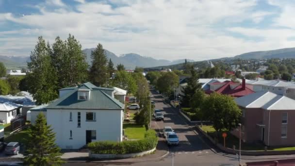 En avant voler au-dessus de la rue bordée de maisons dans quartier résidentiel calme de la ville. Crête de montagne en arrière-plan. — Video