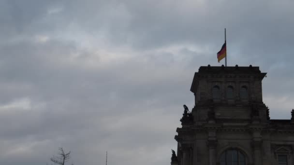Német zászló lengett a parlament történelmi épületén. Döntse le felfedi az emberek az utcán és Fernsehturm a háttérben. Berlin, Németország — Stock videók