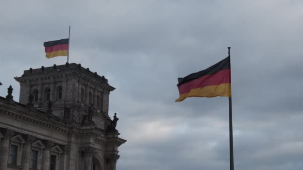 Nationalflaggen am historischen deutschen Parlamentsgebäude. Fließende Symbole gegen bewölkten Himmel. Berlin, Deutschland — Stockvideo