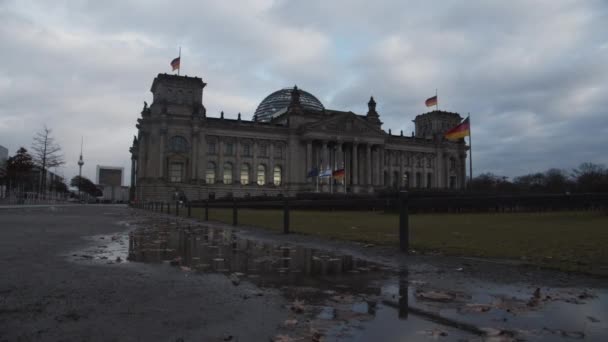 Yol üzerindeki su birikintisi parlamento binasını yansıtıyor. Modern tasarım çelik ve cam kubbeye sahip tarihi eser. Berlin, Almanya — Stok video