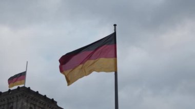 Rüzgarda sallanan bir çift Alman bayrağı. Gökyüzüne karşı kutuptaki ulusal sembolü kapat. Berlin, Almanya