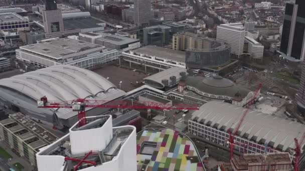 Luchtbeelden van kleurrijk dak op modern gebouw bij Messe hallen. Vlieg over torenkraan op bouwplaats. Frankfurt am Main, Duitsland — Stockvideo