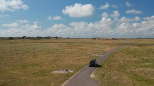 Suivi de la conduite automobile sur la route goudronnée étroite entourée de prairies et de prairies. Paysage plat et vert par temps ensoleillé. Danemark — Video