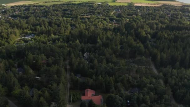 Images panoramiques aériennes du paysage. Bâtiments entre arbres dans la forêt, les champs et les pâturages. Parc éolien à distance. Danemark — Video