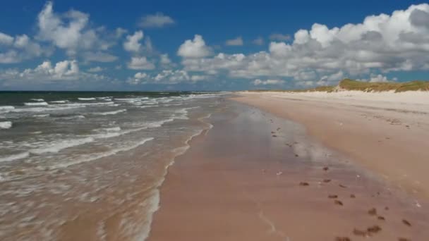 海岸線上空の低飛行。晴れた日に砂浜を洗う波。夏休みの場所。デンマーク — ストック動画