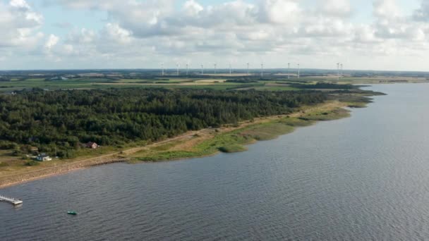 Aerial panoramic footage of coastal landscape, woods and grasslands in countryside. Wind park providing green sustainable energy. Denmark — Stock Video