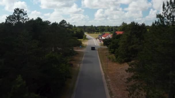 继续追踪在小村庄路上开车的车辆。骑着狗骑在自行车道上的骑手。丹麦 — 图库视频影像