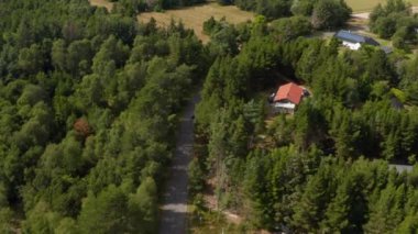 Köyden geçen arabanın yüksek açılı görüntüsü. Kırsal kesimdeki yol çevresindeki ağaçlar. Danimarka