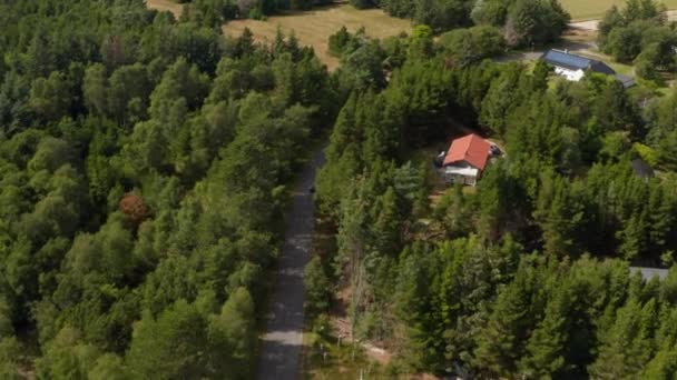 High angle view of car driving on road passing through village. Trees around road in countryside. Denmark — Stock Video