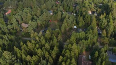 Tatil yerinin üstünde uçmak, ağaçlar arasında evler ve kulübeler. Forrest güneşe ve rüzgara karşı koruma sağlıyor. Danimarka