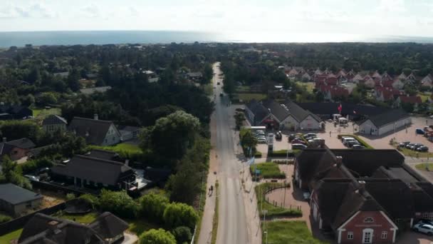 Baglæns afslører af bygninger i lille kystby. Havoverfladen i afstand. Sommerferiedestination. Danmark – Stock-video