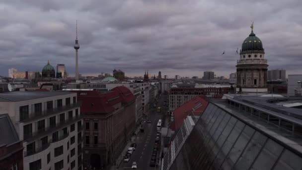 Leť nad ulicí ve městě. Cityscape se známými památkami tyčícími se nad střechami. Franzosischer, Berliner Dom a Fernserturn proti zatažené obloze. Berlín, Německo — Stock video