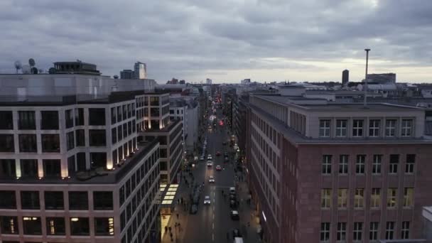 Auta jedoucí po dlouhé rovné ulici ve městě. Za soumraku leťte nad Friedrichstrasse. Berlín, Německo — Stock video