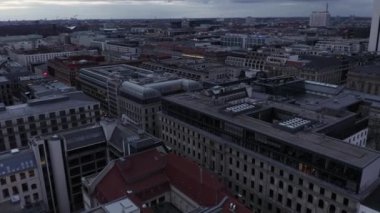 Alacakaranlıkta çok katlı binaların üzerinde uçun. Apartman blokları ve ticari binalar. Berlin, Almanya