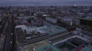 İleriye doğru alacakaranlıkta şehrin üzerinde uçun. Kentsel çevredeki binaların blokları. Hava bulutlu. Berlin, Almanya
