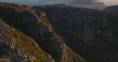 Altın saatinde kaya dağı manzarası. Milli parkın, tepelerin ve yüksek kaya duvarlarının üzerinden uç. Kırık taş bloklar. Cape Town, Güney Afrika