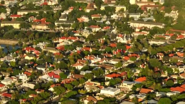 住宅区房屋的高角度视图.在城里的建筑物上空飞行。明亮的阳光照射在市区附近.南非开普敦 — 图库视频影像