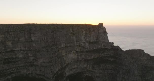 Parede de rocha gigantesca e cume plano da Montanha Mesa. Vista contra o pôr do sol romântico. Cidade do Cabo, África do Sul — Vídeo de Stock