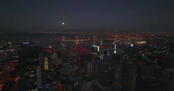 Слайд и панорамный снимок вечерней гавани в морской бухте. Летите над зданиями в центре города после заката. Кейптаун, ЮАР — стоковое видео