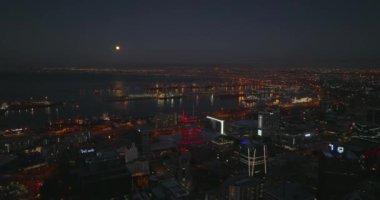 Şehir merkezinin ve gece büyük limanın havadan çekilmiş görüntüleri. Aydınlatılmış binalar ve sokak ışıkları. Cape Town, Güney Afrika