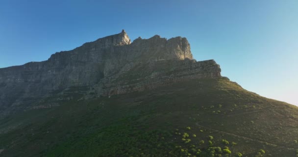 Alacsony szögű kilátás magas meredek sziklafalak Asztali hegyen. Repülj át a tájon a nemzeti parkban a napsütéses napon. Fokváros, Dél-Afrika — Stock videók