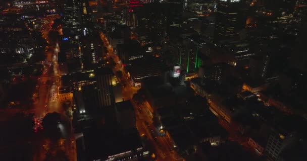 High angle view of orange illuminated streets in night city. Fly above blocks of buildings divided by rectangle road network. Cape Town, South Africa — Stock Video