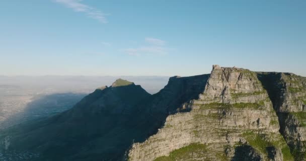 Massiccio crinale roccioso con cima appiattita. Vola intorno alla famosa Table Mountain. Un lato illuminato dal sole, uno in ombra. Città del Capo, Sud Africa — Video Stock