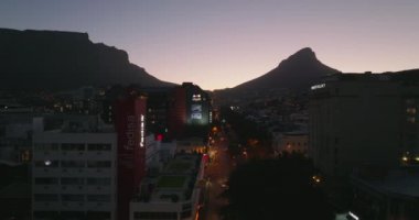 Şehir çevresindeki işlek yolun üzerinde ilerliyorlar. Romantik renkli alacakaranlık gökyüzü. Cape Town, Güney Afrika