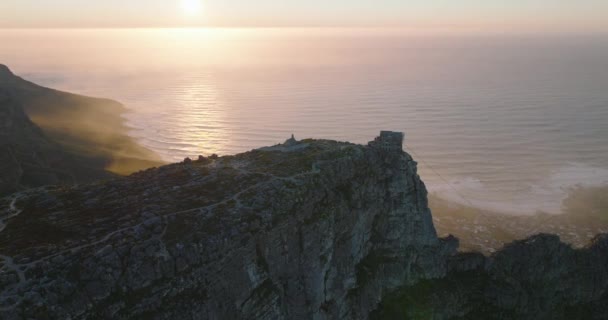 海の海岸で山の風景の空中ロマンチックな映像。表山のスライドとパンショット。太陽の光に対して表示します。南アフリカ共和国ケープタウン — ストック動画