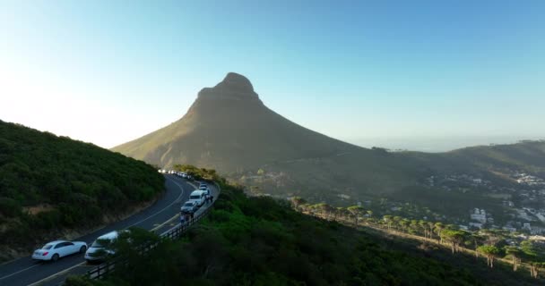 Lions Head 'in inanılmaz görüntüsü şehrin yerleşim yerlerinden yükseğe doğru yükseliyor. Arabalar yol kenarına park edilmiş. Cape Town, Güney Afrika — Stok video