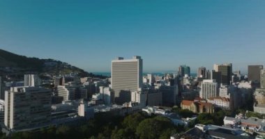 Yüksek katlı ofis binası diğer şehir gelişiminin çok üstünde. Açık gökyüzü ve parlak güneş. Cape Town, Güney Afrika