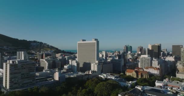 Högt uppsatt kontorsbyggnad högt över annan stadsutveckling. Klar himmel och ljus sol. Kapstaden, Sydafrika — Stockvideo