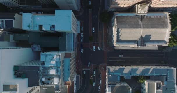 Aves aéreas vista desde arriba hacia abajo panorámica de los edificios a lo largo de la calle en el centro de la ciudad. Coches pasando por el cruce de caminos. Ciudad del Cabo, Sudáfrica — Vídeos de Stock