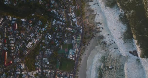Aves aéreas vista arriba hacia abajo vista de olas de mar agitadas rodando en la costa de la ciudad. Ciudad del Cabo, Sudáfrica — Vídeos de Stock