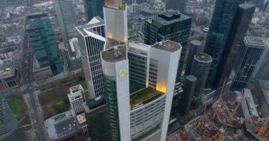 Commerzbank Kulesi 'nin üst kısmının görüntüsünü geri çek. Yukarı doğru eğil şehir merkezindeki gökdelenleri ve şehir manzarasının puslu görüntüsünü ortaya çıkar. Frankfurt am Main, Almanya