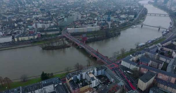 Imágenes panorámicas aéreas del ancho río que fluye a través de la ciudad. Diapositiva y panorámica del tráfico en el viejo puente de carretera. Iglesia en el paseo marítimo. Frankfurt am Main, Alemania — Vídeo de stock